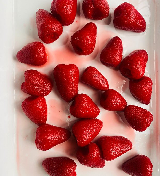 close-up of red canned strawberries in glossy syrup